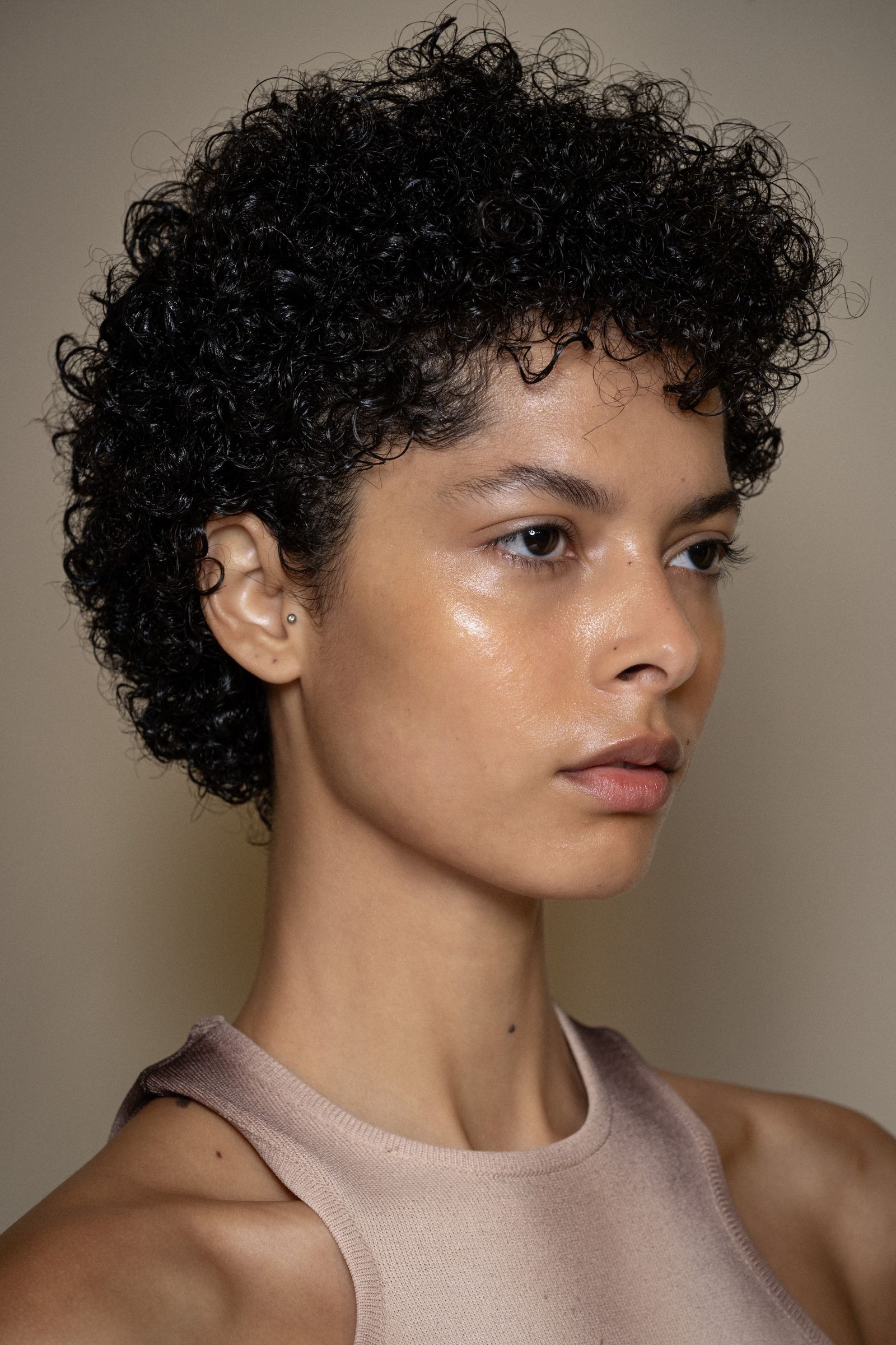 Modelo no desfile da Andreadamo, com corte de cabelo afro curto e definido.