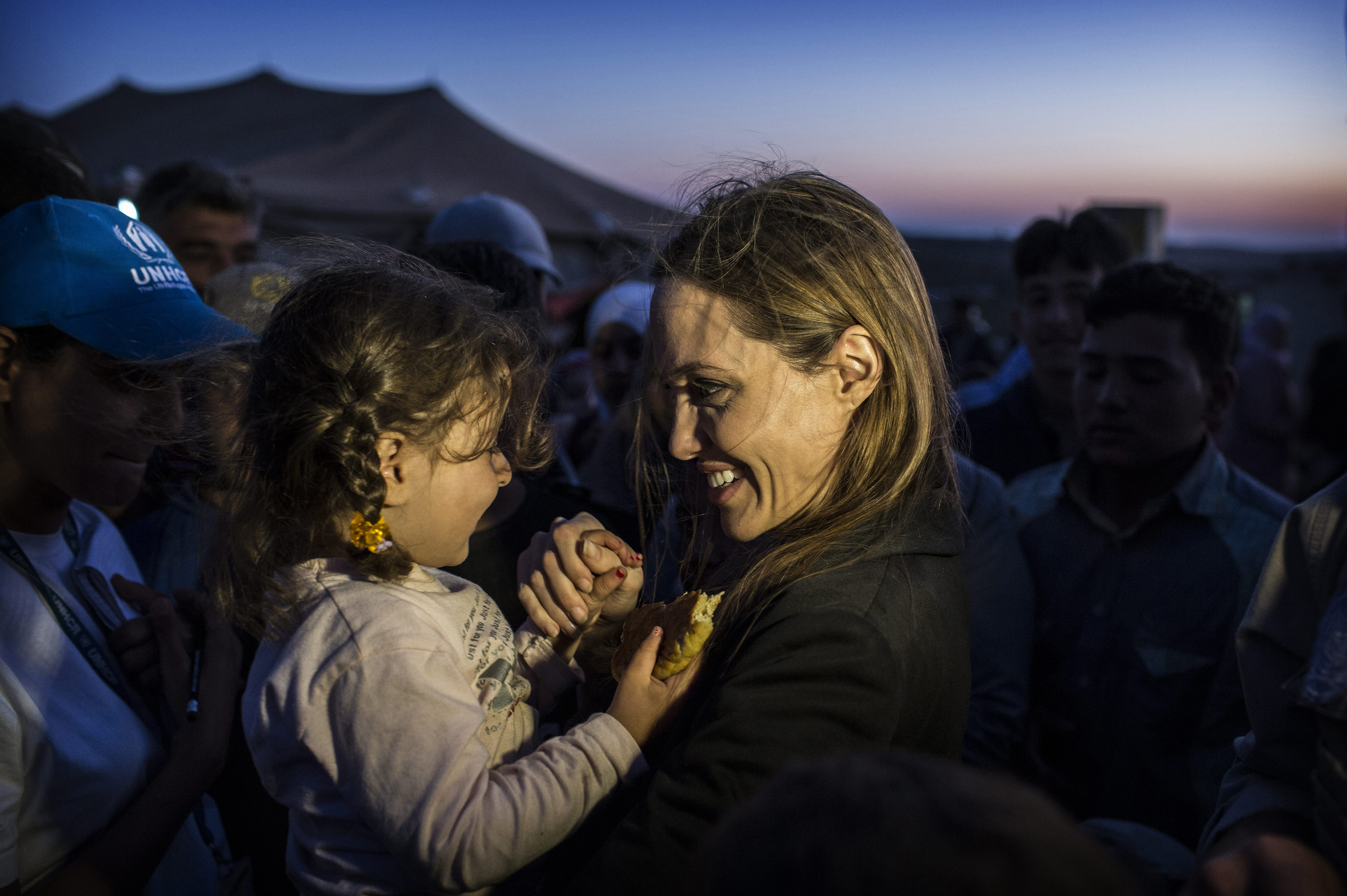 Angelina Jolie fala com uma criança síria num campo militar na Jordânia