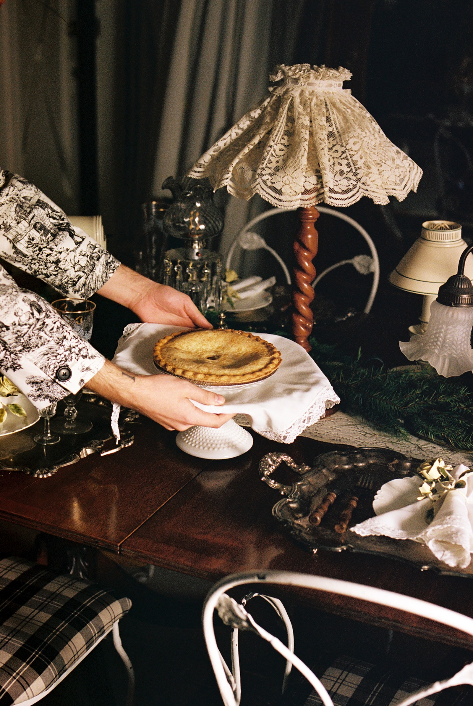 Fletcher Kasell, metade do duo Tanner Fletcher, coloca uma tarte de maçã numa boleira vintage na sua mesa festiva. “É suposto sentirmo-nos como se estivéssemoss num mundo nostálgico, mas ao mesmo tempo moderno”, diz Kasell sobre a decoração de mesa.