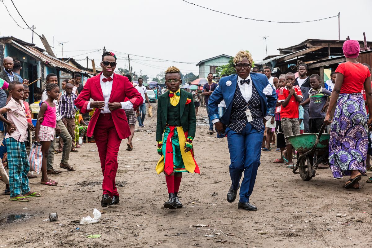 Ntsimba Marie Jeanne, 52-year-old businesswoman and sapeuse for 20 years, Okili Nkoressa, 10-year-old school student and sapeur for 5 years, and Judith Nkoressa, 39-year-old policewoman and sapeuse for 18 years, in Brazza- ville, 2017 © Tariq Zaidi