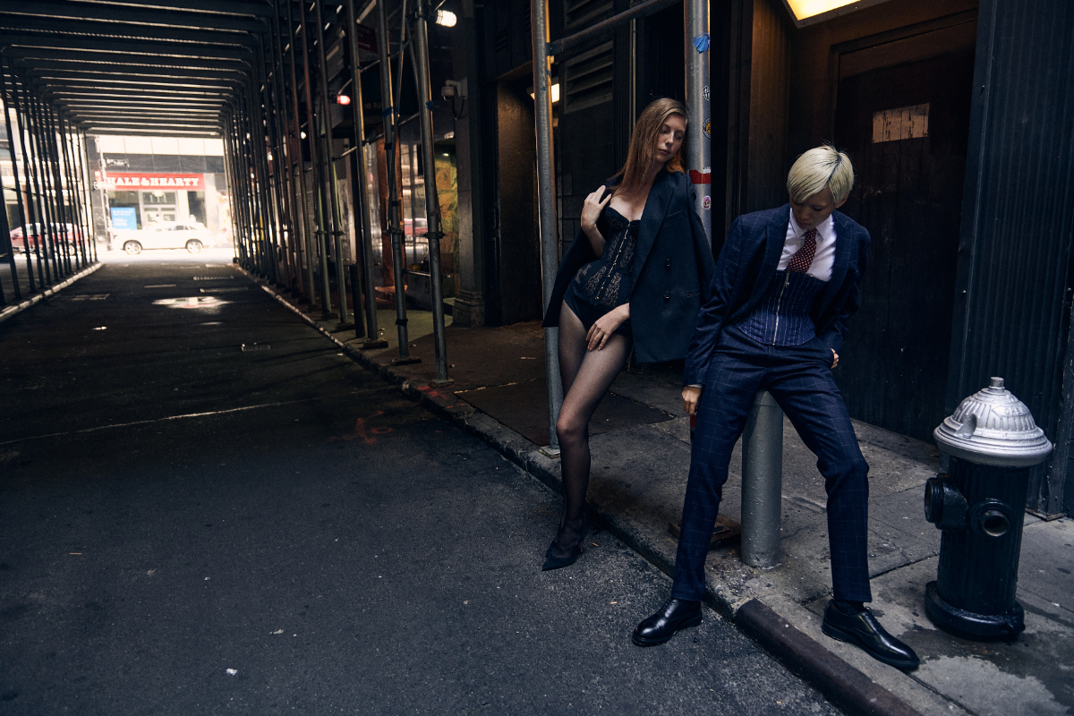 Polina: blazer, ACNE STUDIOS. Corset, AGENT PROVOCATEUR. Cuecas, PRADA. Collants, FALKE. Sapatos, GIANVITO ROSSI. Soonya: blazer, camisa, calças e gravata, tudo RALPH LAUREN. Corset, MIAOU. Botas, GIANVITO ROSSI.