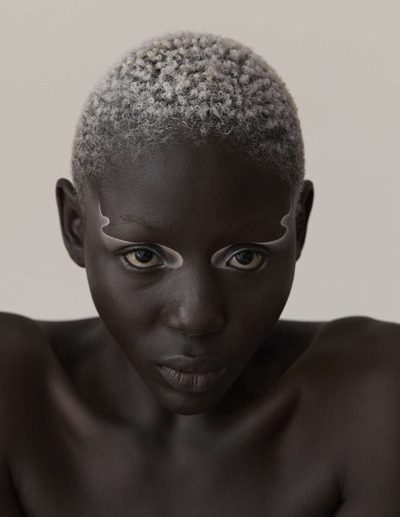 Pigmento em pó (usado nos lábios) Face And Body Paint, no tom White, TAG BODY ART. Base Backstage Face & Body, no tom 9 Neutral, € 43,99, DIOR, e corretor Radiant Creamy Concealer, no tom Café, € 33,90, NARS, ambos em SEPHORA.PT. Sombra de olhos Eye Shadow, no tom Gesso, € 22, e iluminador Cream Colour Base, no tom Hush, € 27, ambos MAC. Pigmentos em pó (usados nos olhos) Face And Body Paint, nos tons White e Rich Ivory, ambos TAG BODY ART. Eyeliner (usado nos lábios), no tom Bronze 15, DOLCE & GABBANA. Bálsamo de lábios The Lip Balm, € 65, LA MER.