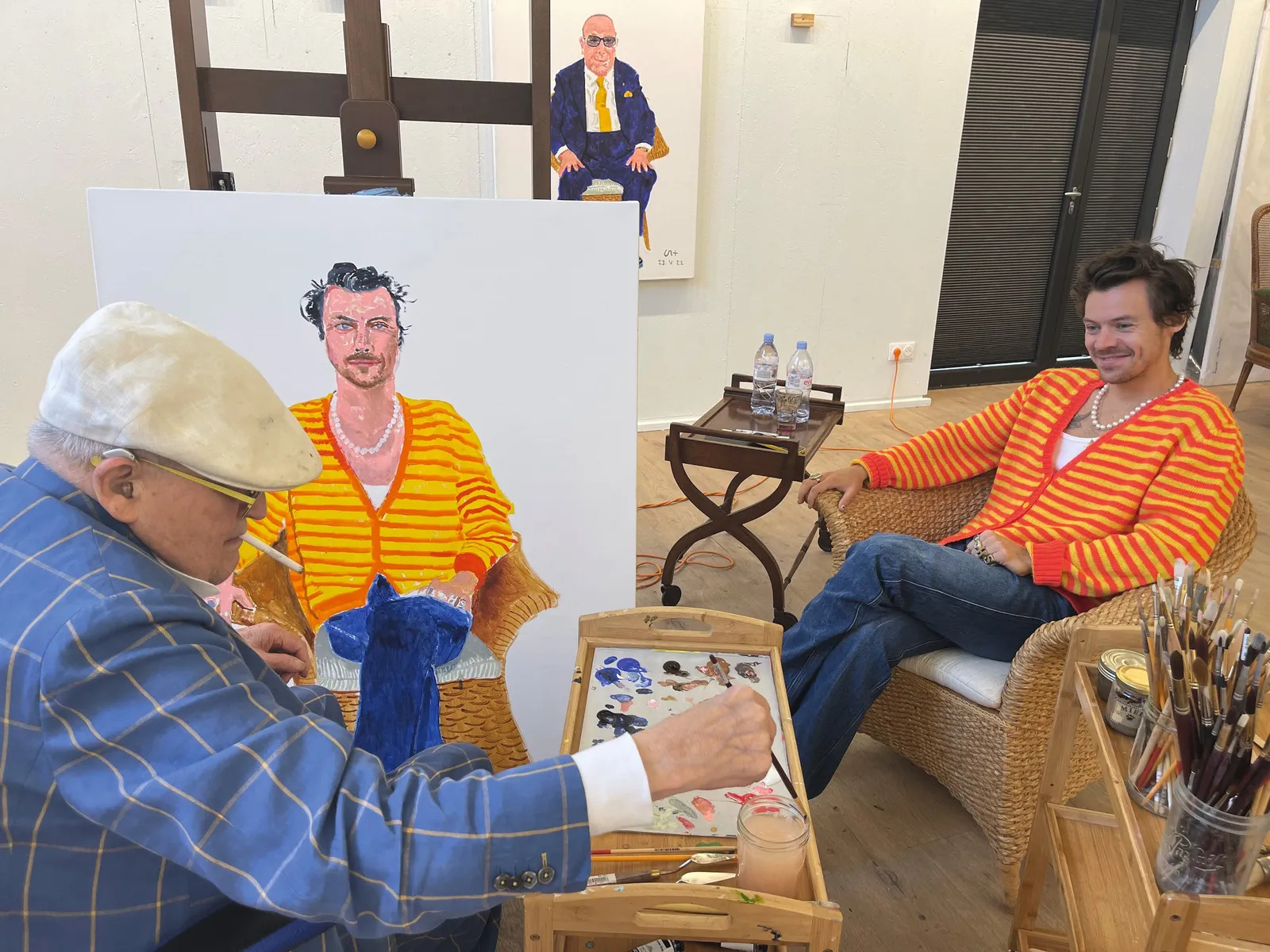 Hockney pinta Harry Styles no seu estúdio na Normandia, onde o retrato de Clive Davis também pode ser visto em segundo plano.