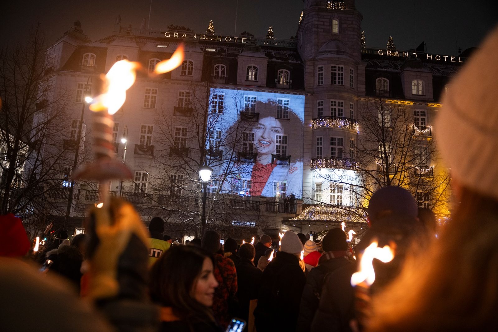 Procissão de tochas em Oslo em honra de Narges Mohammadi, Prémio Nobel da Paz. Os iranianos na Noruega reuniram-se para celebrar a segunda vitória histórica de uma mulher iraniana. Uma vez que Narges não pôde estar presente, um retrato seu, da autoria de Reihane Taravati, foi projetado na parede do Grand Hotel, enquanto a canção “Baraye”, de Shervin Hajipour, tocava bem alto para o público.