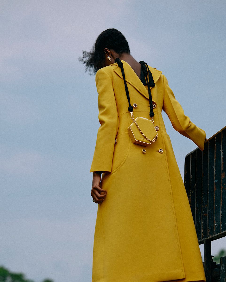 Trench coat, sapatos e carteira, tudo Prada. Brincos, Christian Dior. Anel em ouro, Sauer.