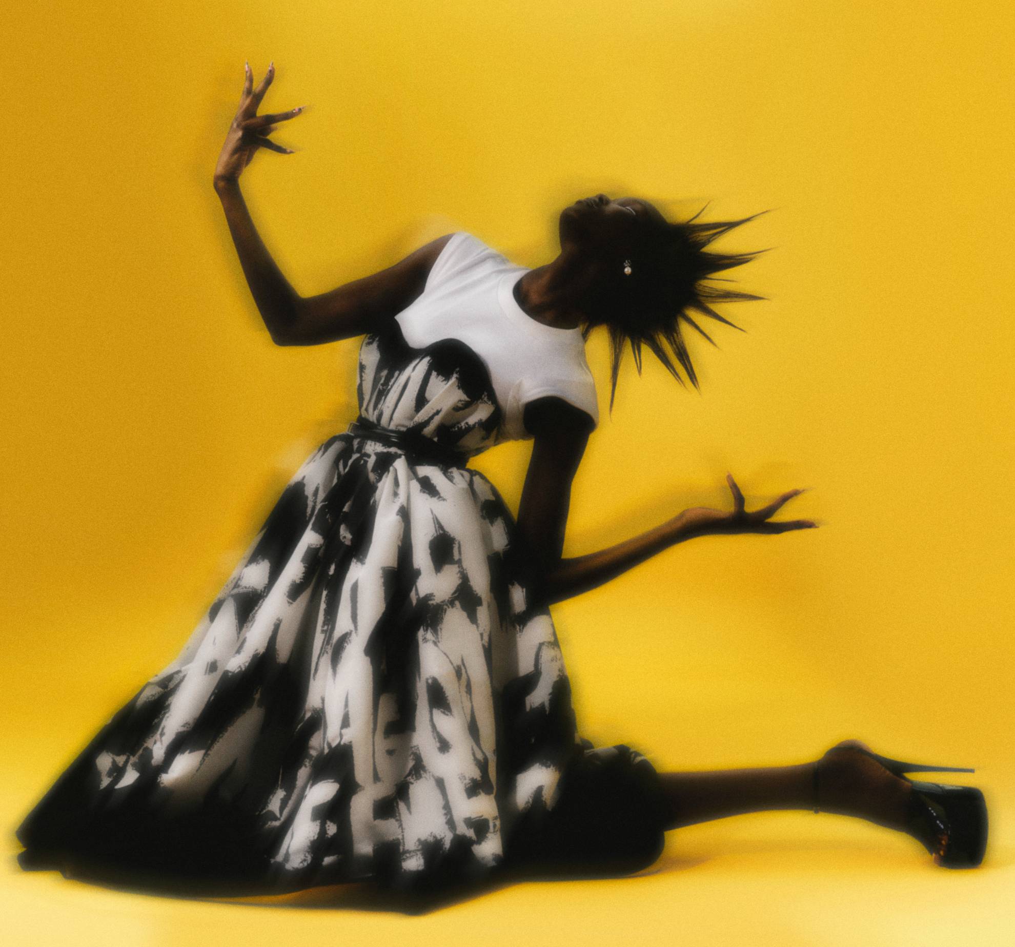 Casaco, JUNYA WATANABE. Vestido, SIMONE ROCHA. Botas, MAISON MARGIELA. Brincos Milla em metal com cristais, JUSTINE CLENQUET. Base Backstage Face&Body Foundation, no tom 9 Neutral, € 42,50, DIOR, em SEPHORA.PT. Corretor Radiant Creamy, no tom D2 Cacao, € 31,50, NARS. Lápis de olhos (usado nos olhos e nos lábios) Aqua Resist Color, no tom Graphite, € 20,99, MAKE UP FOREVER, em SEPHORA.PT. Eyeliner AMC, no tom 77, € 15,90, INGLOT. Gloss Lipglass, no tom Clear, € 21,50, MAC, em PERFUMESECOMPANHIA.PT.