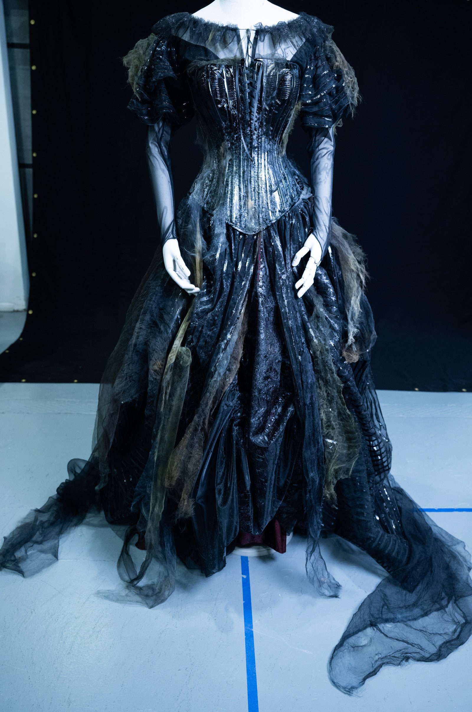 Imagens da esquerda para a direita: Um vestido usado por Jenna Ortega, um fato usado por Michael Keaton, e um vestido usado por Monica Bellucci. Imagens da esquerda para a direita: Um vestido usado por Jenna Ortega, um fato usado por Michael Keaton, e um vestido usado por Monica Bellucci.