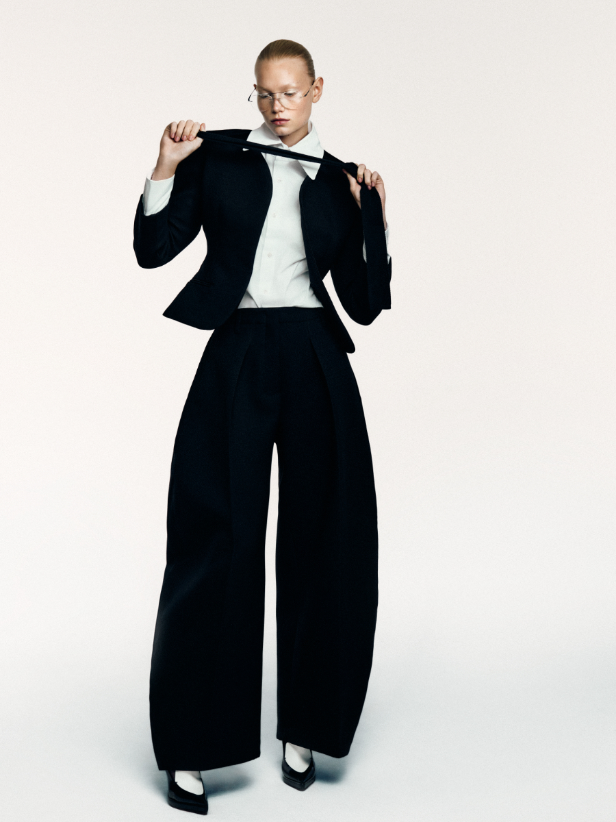 Blazer e calças, JACQUEMUS. Camisa, SAINT LAURENT BY ANTHONY VACCARELLO. Gravata, PRADA. Soutien, DOLCE & GABBANA. Óculos, MIU MIU. Sapatos, CELINE.