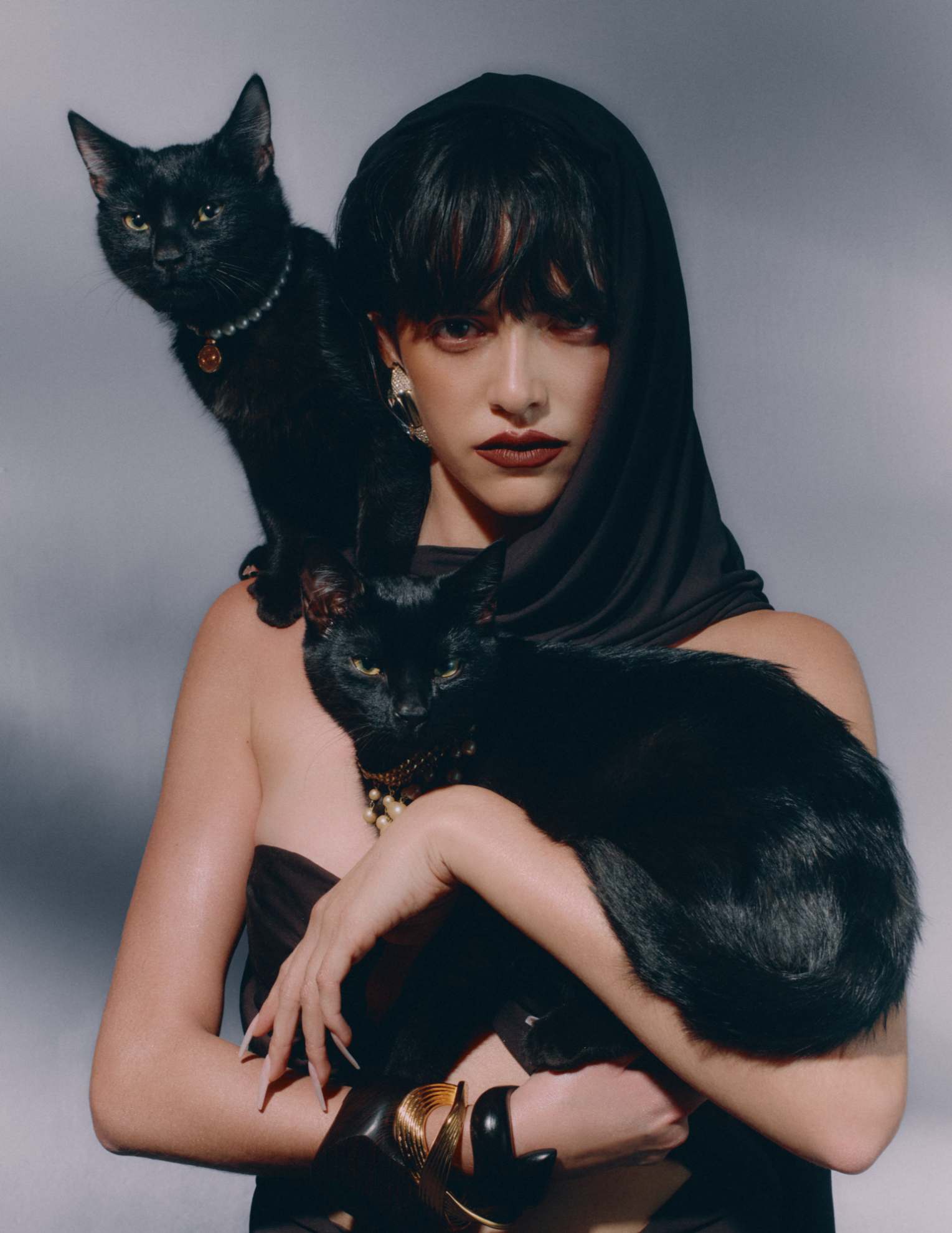 Vestido, brincos e pulseiras, tudo SAINT LAURENT BY ANTHONY VACCARELLO. Gato (em cima): choker Słonce, ANNA SAMKOW. Gato (em baixo): choker vintage, da produção. Base Forever Skin Glow, no tom 2N, € 57, DIOR. Corretor Radiant Creamy, no tom Light, € 32, NARS. Gel de sobrancelhas Fluff Up, € 30,99, BENEFIT COSMETICS, e batom Liquid Matte Ultra-Comfort Transfer-Proof, no tom First Class, € 23,99, HUDA BEAUTY, em SEPHORA.PT. Iluminador Killawatt Freestyle, no tom Trophy Wife, € 45, FENTY BEAUTY. Sombra de olhos da coleção Backstage Eye, no tom 001 Warm Neutrals, € 54, DIOR.