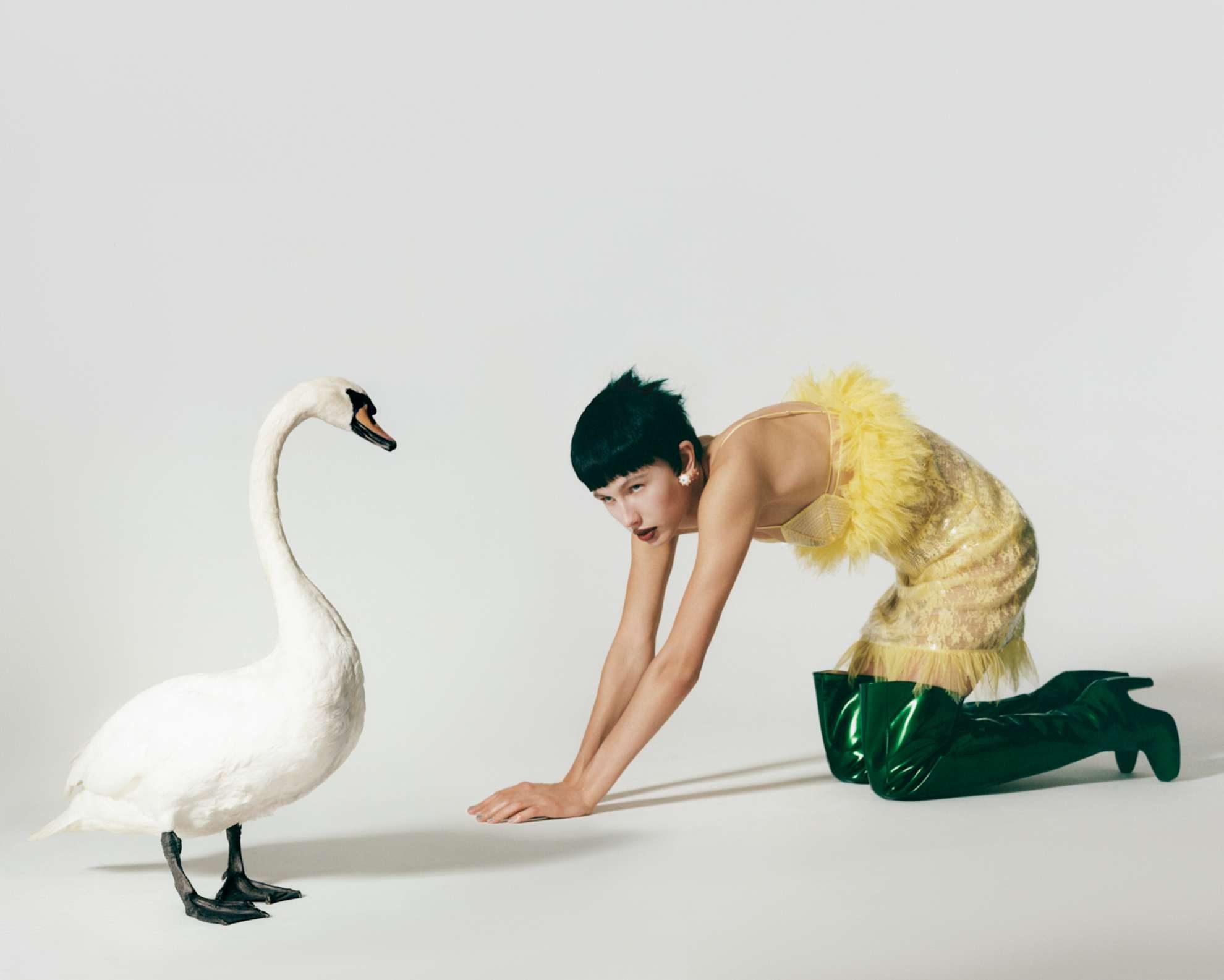 Vestido, brincos em prata de lei banhada a ouro amarelo e botas, tudo BOTTEGA VENETA.