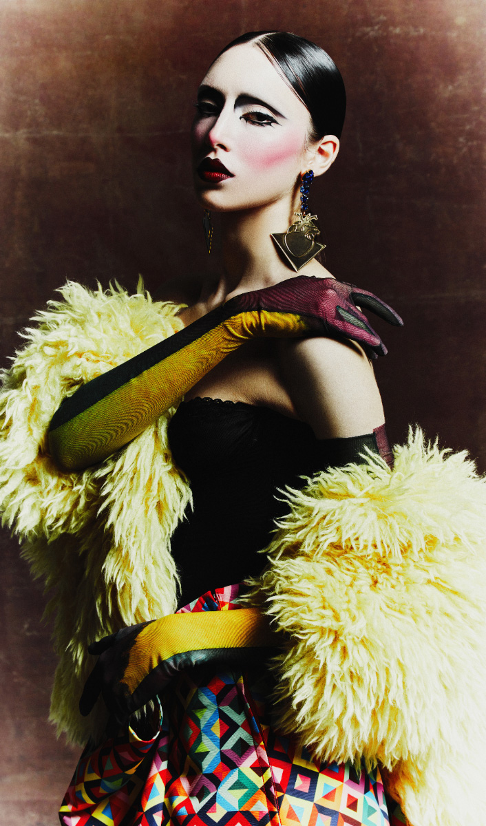 Casaco, SPORTMAX. Corset, MUGLER. Saia, COMME DES GARÇONS. Chapéu, RUSLAN BAGINSKI. Joias, MATISSE RENVER. Luvas, DRIES VAN NOTEN. Collants, LAUREN PERRIN. Sapatos, ROBERTO FESTA.