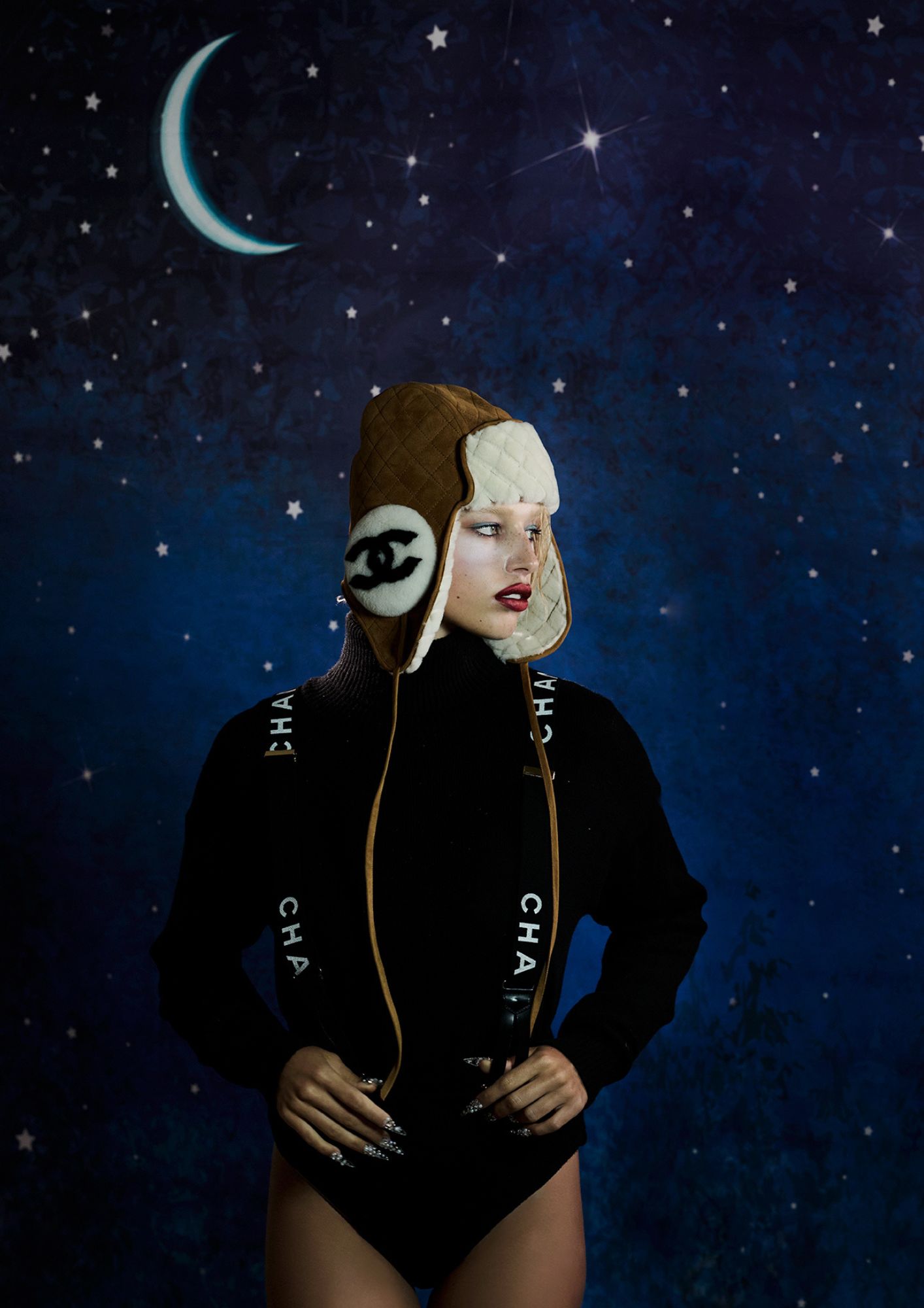 Casaco, MONCLER. Base, Studio Radiance no tom C3, € 45, MAC COSMETICS em PERFUMES&COMPANHIA.PT. Lápis Satin Kajal Liner no tom Black, € 39, em VICTORIA BECKHAM. Sombra de olhos da paleta Pro Palette Paintstick x12 nos tons High Def Cyan e Pure White, MAC COSMETICS. Máscara de pestanas Lash Clash no tom Noir, € 45,99, YVES SAINT LAURENT em DOUGLAS.PT. Batom Powder Kiss Lip + Cheek Mousse no tom Ruby Boo, MAC COSMETICS. Batom Rouge Allure Laque no tom 91 Fancy Prune, CHANEL BEAUTY. Pedras usadas na cara, MICHAELS; Camisola, cuecas, chapéu e suspensórios, tudo CHANEL. Base, Studio Radiance no tom C3, € 45, MAC COSMETICS em PERFUMES&COMPANHIA.PT. Lápis Satin Kajal Liner no tom Black, € 39, em VICTORIA BECKHAM. Sombra de olhos da paleta Pro Palette Paintstick x12 no tom Pure White, MAC COSMETICS. Máscara de pestanas Lash Clash no tom Noir, € 45,99, YVES SAINT LAURENT em DOUGLAS.PT. Batom Powder Kiss Lip + Cheek Mousse no tom Ruby Boo, MAC COSMETICS. Batom Rouge Allure Laque no tom 91 Fancy Prune, CHANEL BEAUTY.